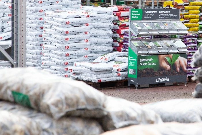Verschiedene Erden und ein Verkaufsständer der Gartenwelt.
